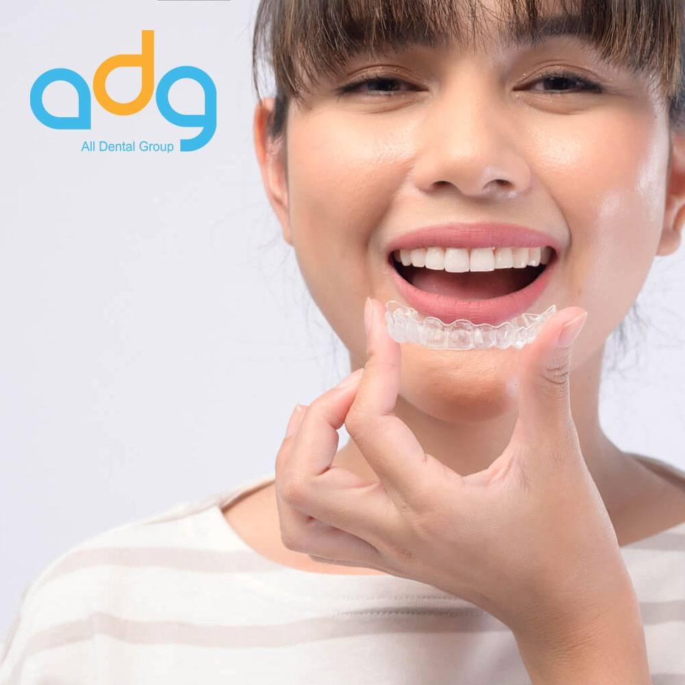 Patient holding a clear Invisalign aligner